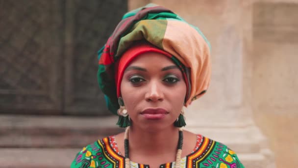アフリカの女性の半分の肖像画を閉じます 構成とターバンを持つ多文化女性 明るい宝石で多民族の女性の詳細画像 真剣な女性の服を着た伝統的な衣装 — ストック動画
