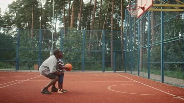 Афроамериканський Дбайливий Батько Проводить Час Сином Відкритому Повітрі Граючи Баскетбол — стокове відео