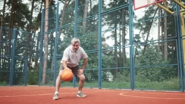 Взрослый Красивый Мужчина Носит Спортивную Одежду Играет Баскетбол Детской Площадке — стоковое видео
