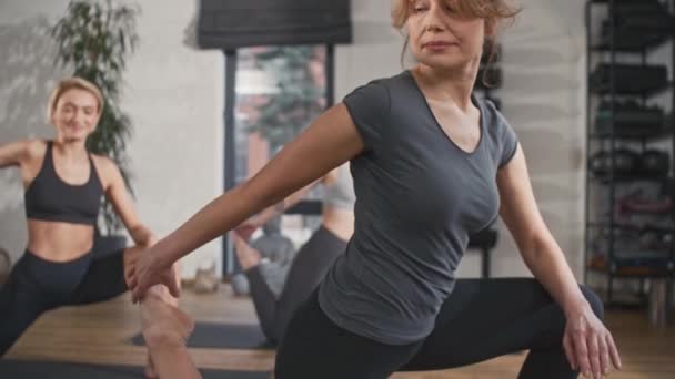漂亮的女人穿着黑色的衣服躺在健康工作室的垫子上积极完成瑜伽练习 享受在他们身上工作的乐趣 照顾好健康 运动的概念 — 图库视频影像