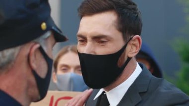 Karantina karşıtı protesto. Polis isyanı bastırmaya çalışıyor. İnsan hakları gösterilerinde genç beyaz protestocu polise bağırıyor ve bağırıyordu. Demokrasi.