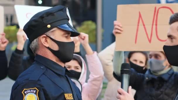 在积极分子示威的背景下 成熟的警察代表接受了男记者记者的采访 在室外直播 反检疫抗议 — 图库视频影像