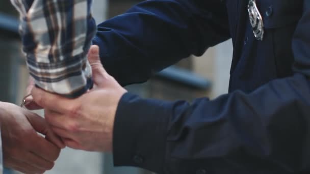 職場の警察官 手錠をかけた泥棒を逮捕する プロの警官のクローズアップ 警察が市をパトロール コントロールと安全コンセプト 市街地の危険な犯罪者 — ストック動画