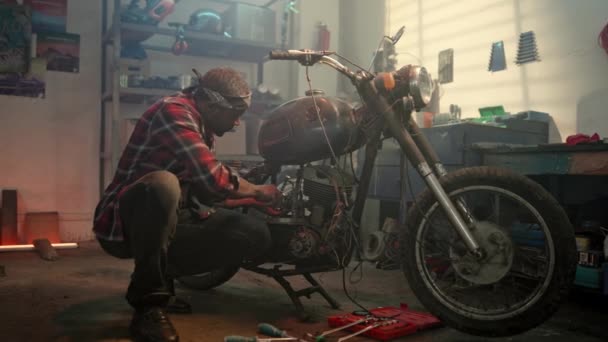 Junge Biker Tuning Motorrad Der Werkstatt Geschlossene Garage Automechaniker Blickt — Stockvideo