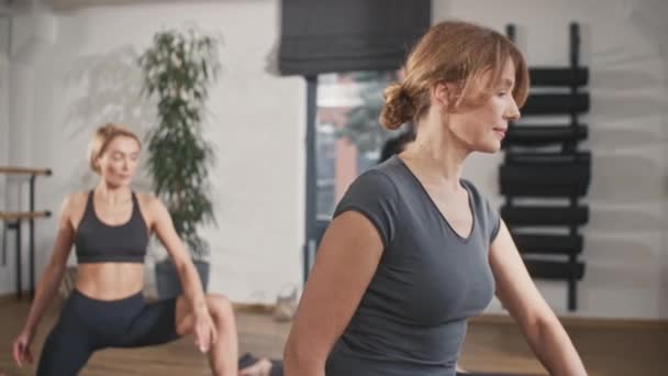 Zespół Sportowych Kobiet Rozciągających Nogi Matach Fitness Przytulnym Centrum Odnowy — Wideo stockowe