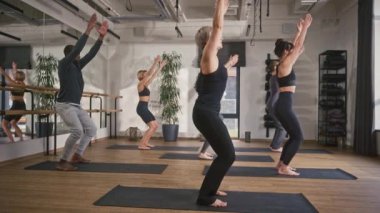 Bir grup insan nasıl nefes alınacağını öğreniyor. Yoga minderlerinin üzerinde düz ellerle yavaşça bükülüyorlar. Beden eğitimi için spor kıyafetleri giyiyor. Daha iyi kan dolaşımı için eğitim.