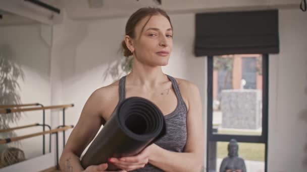 Pelatih Yoga Profesional Melirik Kamera Memegang Tikar Yoga Dan Bersiap — Stok Video