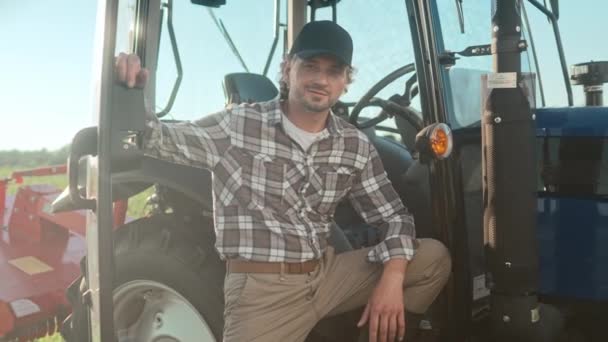 Traktorfahrer Steht Mit Einer Hand Auf Traktormaschine Glückliche Landarbeiter Die — Stockvideo