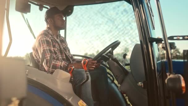 Afroamerikanischer Traktorfahrer Steuer Mann Fährt Traktormaschine Auf Feld Fröhlicher Bauer — Stockvideo