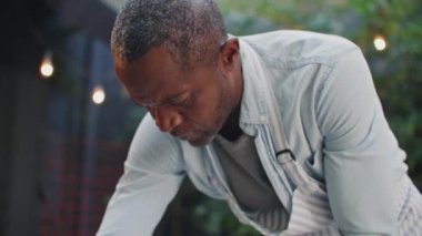 Çalışan üniformalı, terasta tozdan masaları cilalayan meşgul bir Afrikalı Amerikalı. İşten sonra kafeyi temizleyen olgun bir garson. Bir sonraki müşterilere masa hazırlayan bir işçi. Görev konsepti.