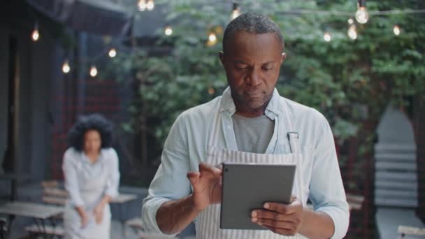 Guapo Afroamericano Dueño Masculino Una Pequeña Cafetería Usando Dispositivo Tableta — Vídeos de Stock