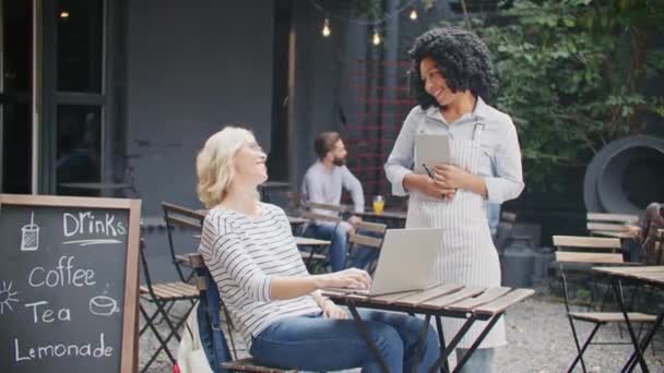 Kafe Terasında Müşteri Kabul Ederken Dostane Afrikalı Amerikalı Garson Neşeli — Stok video