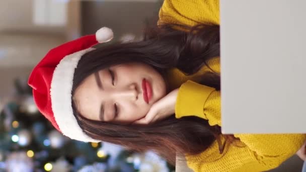 Вертикальное Видео Симпатичная Азиатка Шляпе Санта Клауса Грустит Сидя Дома — стоковое видео