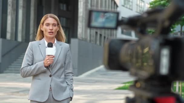 美丽的白人女记者用麦克风为大众媒体讲故事 专业人员在报道新闻时看着摄像机 在电视上工作电视行业 — 图库视频影像