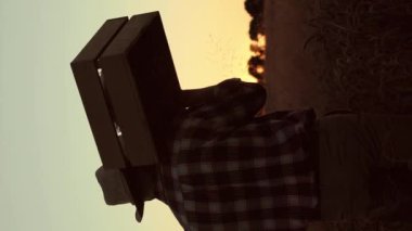 Buğday tarlasında yürürken şapka takan bir adamın arka planı. Tohumlu ya da hasatlı sandık taşıyan çalışkan bir çiftçi. Tarım bitkileri yetiştiriyor. Olgun dikenli çukur manzarası. Mevsimlik iş.