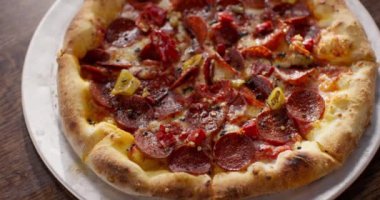 Lezzetli pizzayla yakın plan. Masada taze pişmiş pizza var. İtalyan pizzası. Yiyecek ve içecek konsepti. Büyük porsiyon. Malzemeler. Salamlı, biberli ve peynirli pizza..