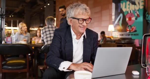 Dorosły Biznesmen Uśmiechający Się Podczas Pracy Nad Laptopem Kawiarni Człowiekiem — Wideo stockowe