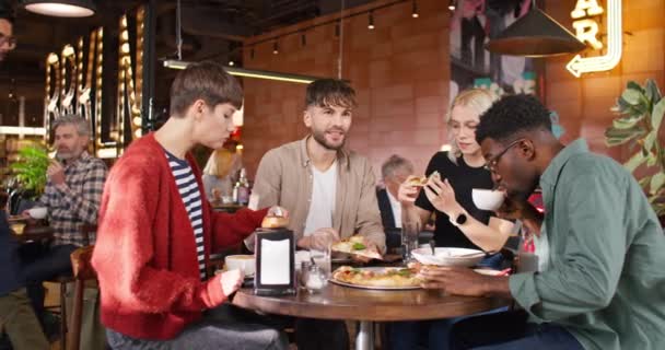 Kompania Czterech Przyjaciół Siedzących Przy Stole Jedzących Smaczną Włoską Pizzę — Wideo stockowe