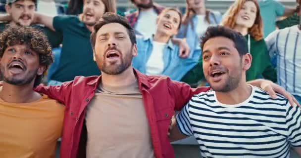 Többnemzetiségű Emberek Ölelgetik Egymást Hangosan Énekelnek Focimeccs Közben Barátságos Szurkolók — Stock videók