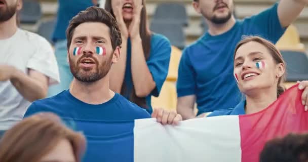 귀여운 코카서스 노래와 경기장 트리뷴에서 무언가를 외치고 팬들은 프랑스 국기를 — 비디오