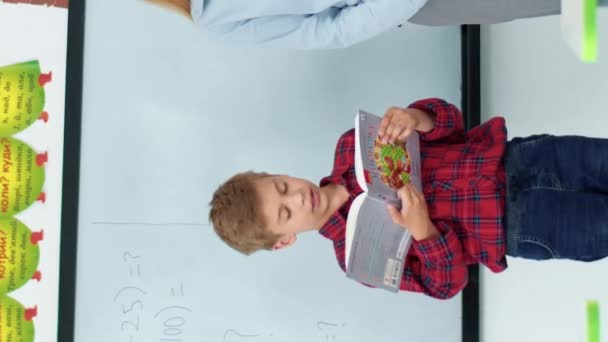 Sınıfın Ortasında Dururken Elinde Kitap Tutan Beyaz Öğrencinin Dikey Görüntüsü — Stok video