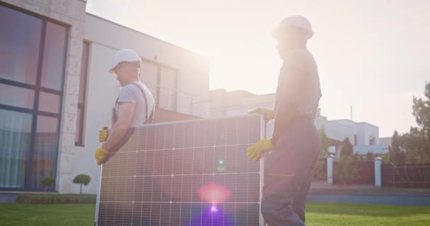 Мультиэтнические Инженеры Устанавливают Альтернативные Источники Энергии Мужчины Подрядчики Несут Солнечную — стоковое видео