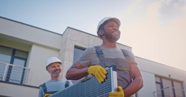Dwóch Uśmiechniętych Wielonarodowych Inżynierów Instalujących Alternatywne Źródło Energii Męscy Kontrahenci — Wideo stockowe