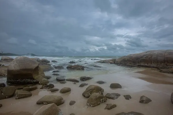 stock image Beautiful shore with rocks on the beach shows rain clouds background