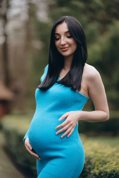 Pregnant brunette, modern mom, poses for the camera