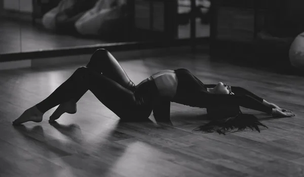 ストレッチブロック上の床の上にスポーツの女の子 バック運動 明るい部屋で 背中の痛みを緩和するのに役立ちます 初心者のための柔軟な体のストレッチ — ストック写真