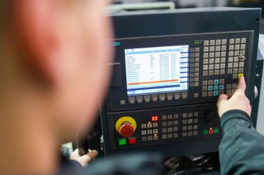 Makine operatörünün el kesimi endüstriyel makinenin kontrol panelini açar. Kontrol panelinde düğmedeki teknisyeni kapat