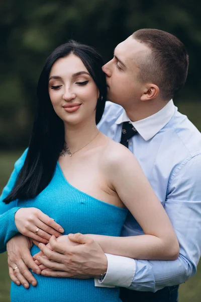一个年轻人小心地吻着他怀孕的妻子的肚子 — 图库照片
