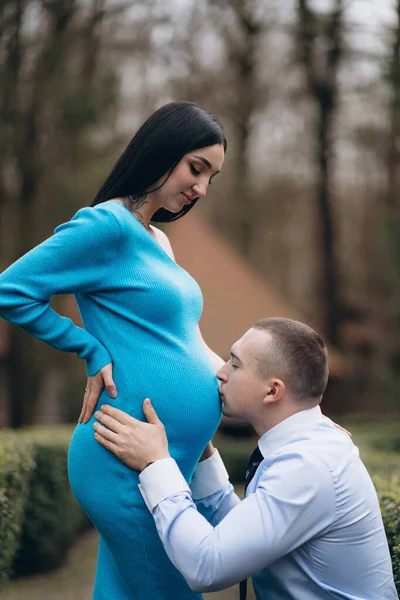 若い男が彼の妊娠した妻の腹にキス — ストック写真