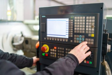 Makine operatörünün el kesimi endüstriyel makinenin kontrol panelini açar. Kontrol panelinde düğmedeki teknisyeni kapat