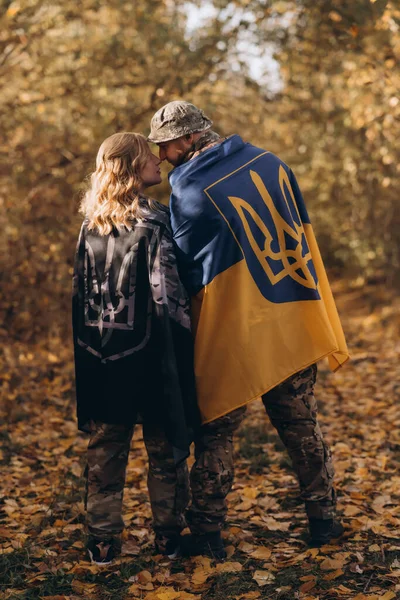 Ukrainian military couple, happy to meet, Ukrainian flag.