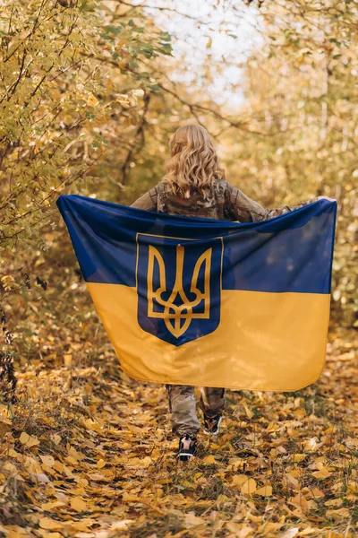 A beautiful Ukrainian woman with a Ukrainian flag on her shoulders.