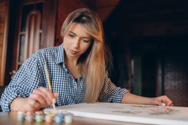 Genç bir kadın resim yapıyor. Arka plan bulanık. Sanat konsepti.