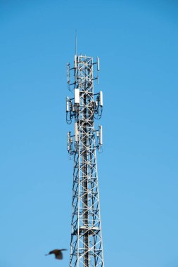 Mavi gökyüzü arkaplanındaki iletişim kulesi.