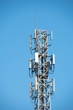 yüksek voltaj direği ve mavi gökyüzü arka planında antenler.