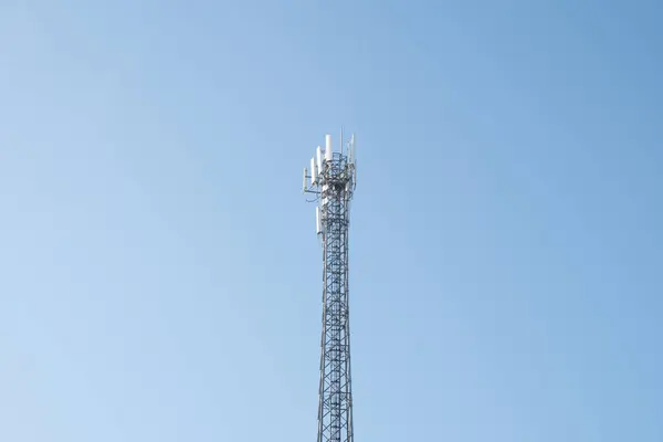 Mavi gökyüzü ve beyaz bulutlu anten kulesi. yüksek - mavi gökyüzü ile bina.