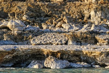 Tuzla kaplı taşlarla ölü deniz kıyısı.