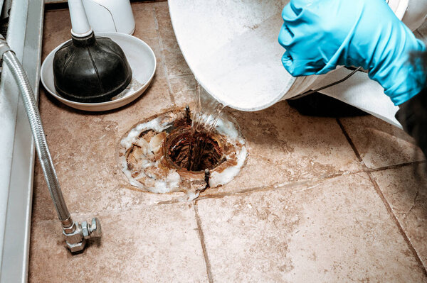 Professional plumber replacing old wax ring seal before toilet installation, captured in a clean composition with copy space.