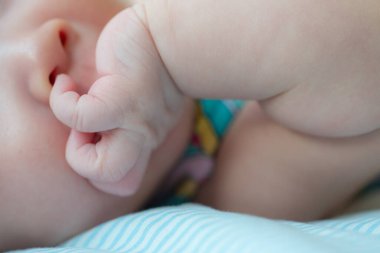 Resim, yeni doğmuş bir bebeğin burnunu sokup meraklarını ve erken motor becerilerini göstererek keşfetmeye çalıştığı sevimli bir anı yakalıyor.