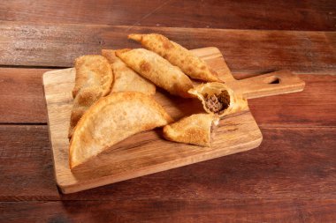 Kızarmış hamur işleri, Pastel Frito Brasileiro, ahşap masada. Pastel de carne.