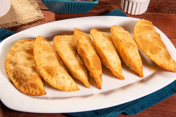 stock image Fried Pastries, Pastel Frito Brasileiro, on wooden table. Pastel de carne