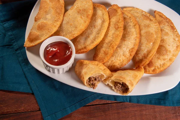 stock image Fried Pastries, Pastel Frito Brasileiro, on wooden table. Pastel de carne