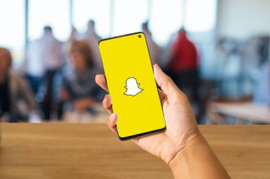 Snapchat logosu olan el ele tutuşan ve arka planda insanları bulanıklaştıran, Rio de Janeiro, Brezilya, Mayıs 2024