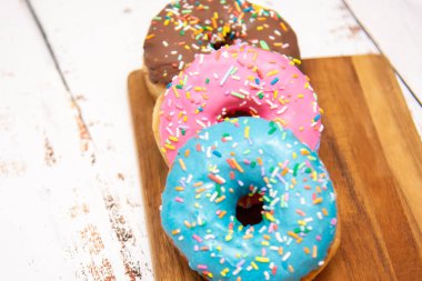 Lezzetli tatlı. Pembe, mavi ve çikolata renkli çörekler..