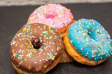 Lezzetli tatlı. Pembe, mavi ve çikolata renkli çörekler..