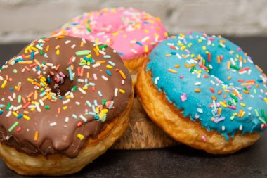 Lezzetli tatlı. Pembe, mavi ve çikolata renkli çörekler..